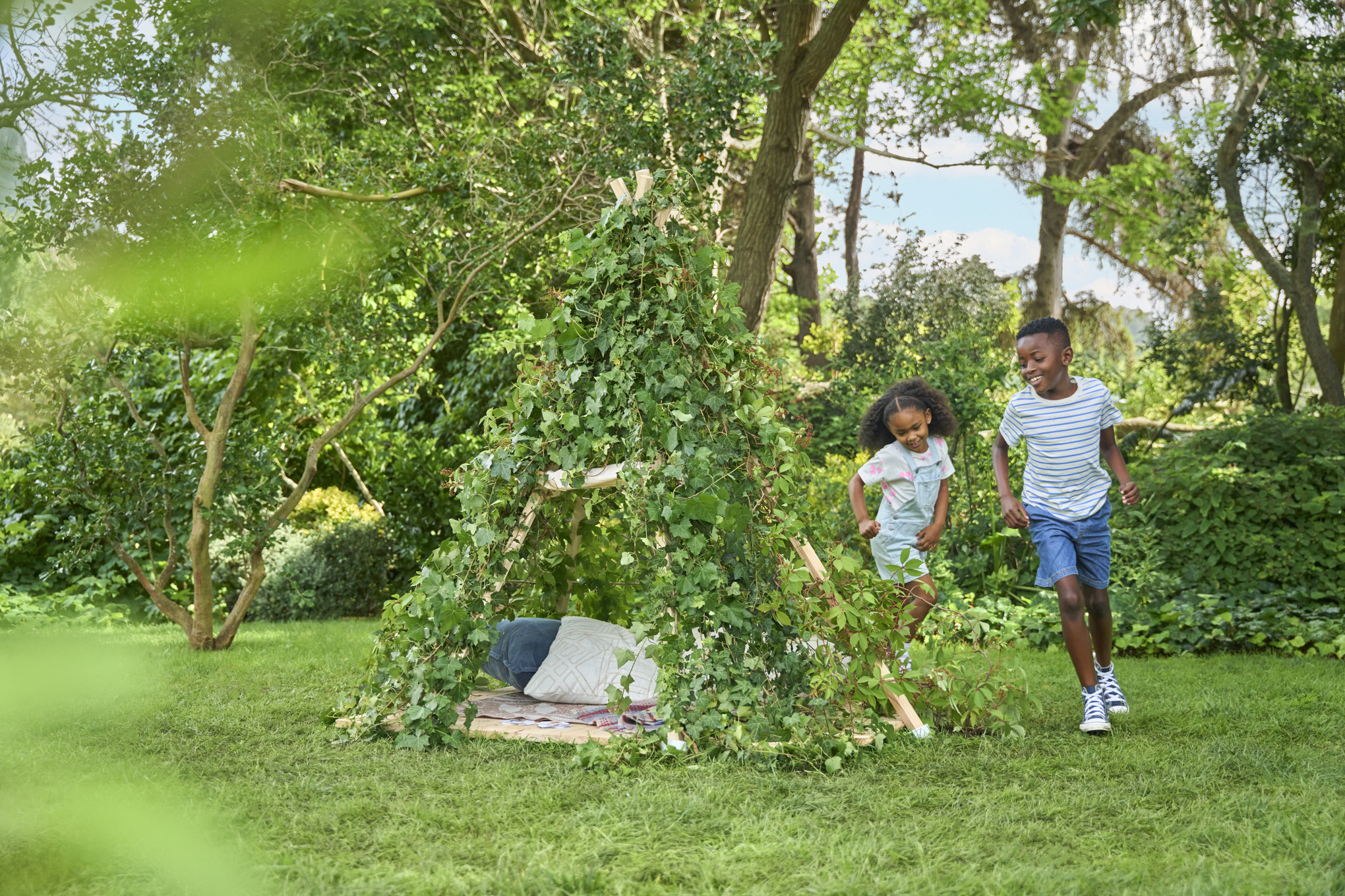 Garden play tent for children with a timber frame and climbing plants