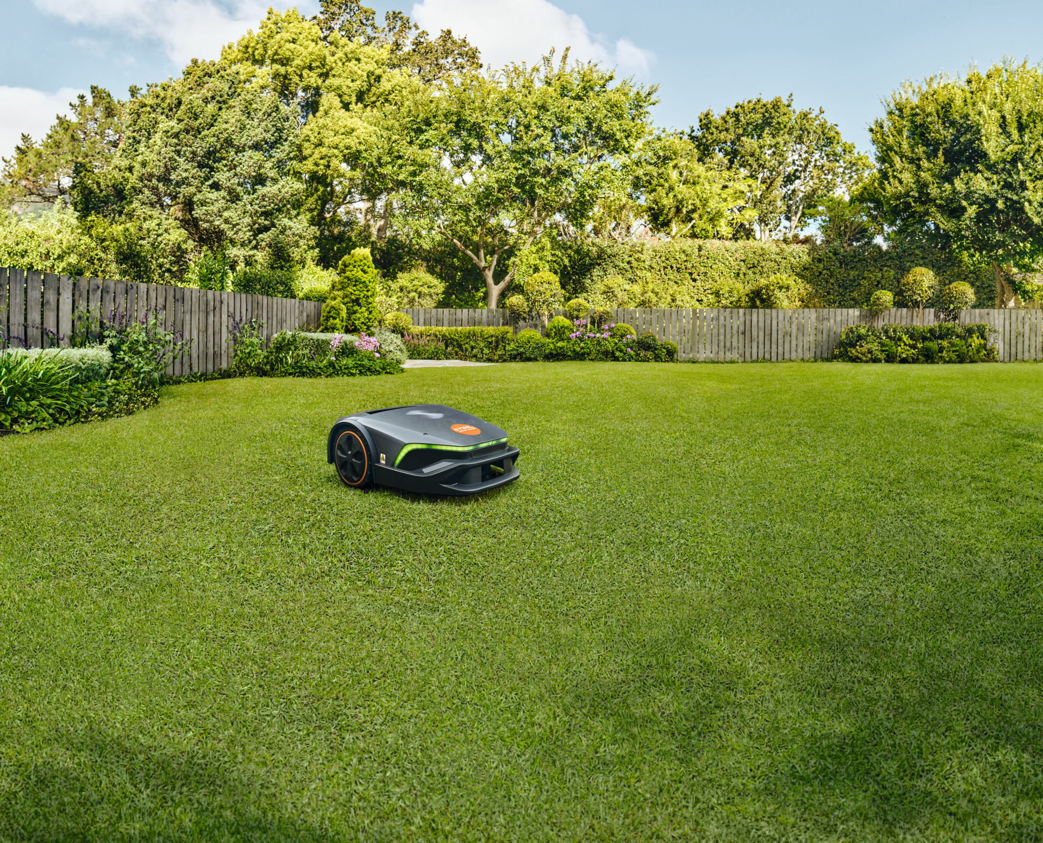 A STIHL iMOW® robot mower on a green lawn